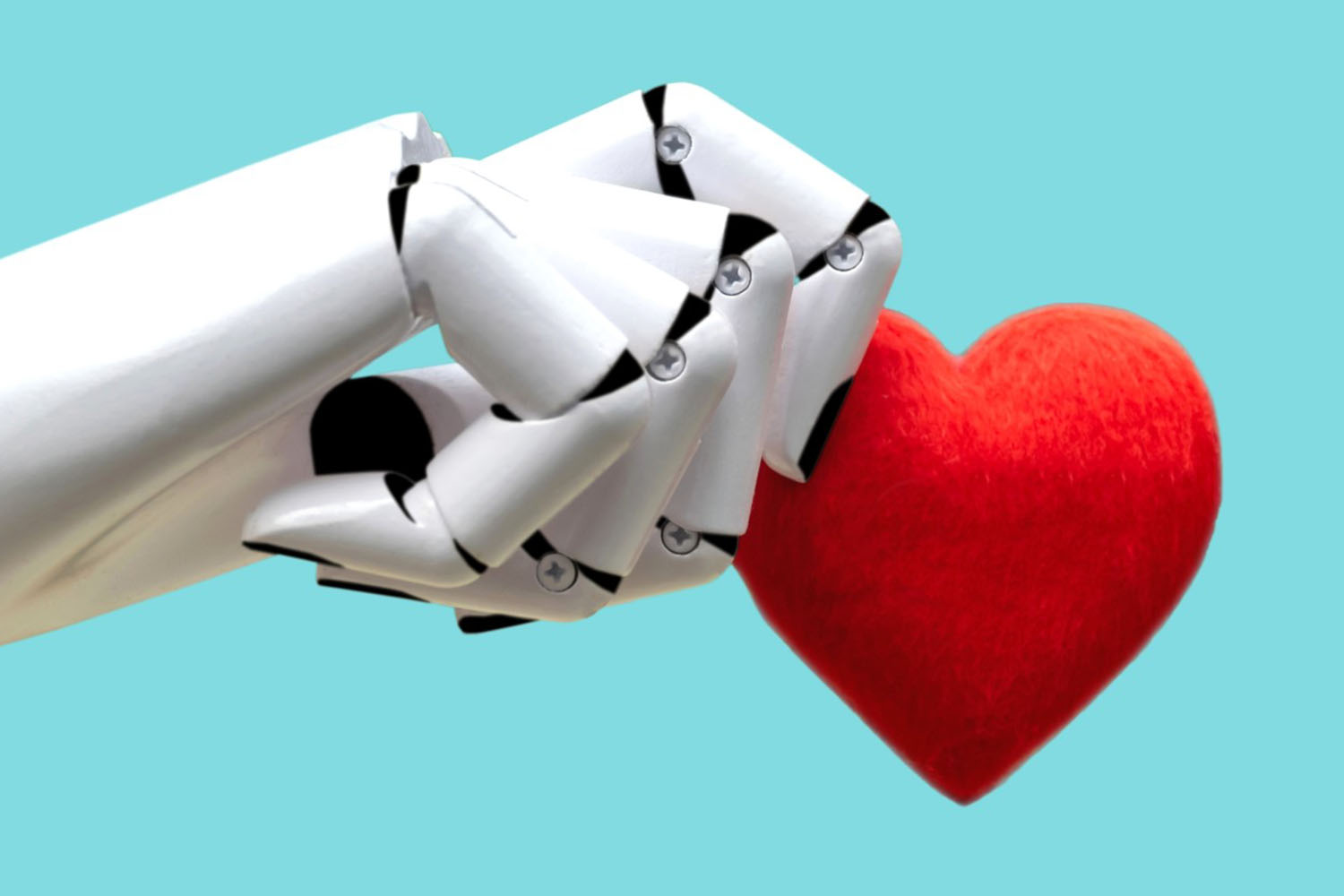 Image of a robot hand holding a felt red heart.