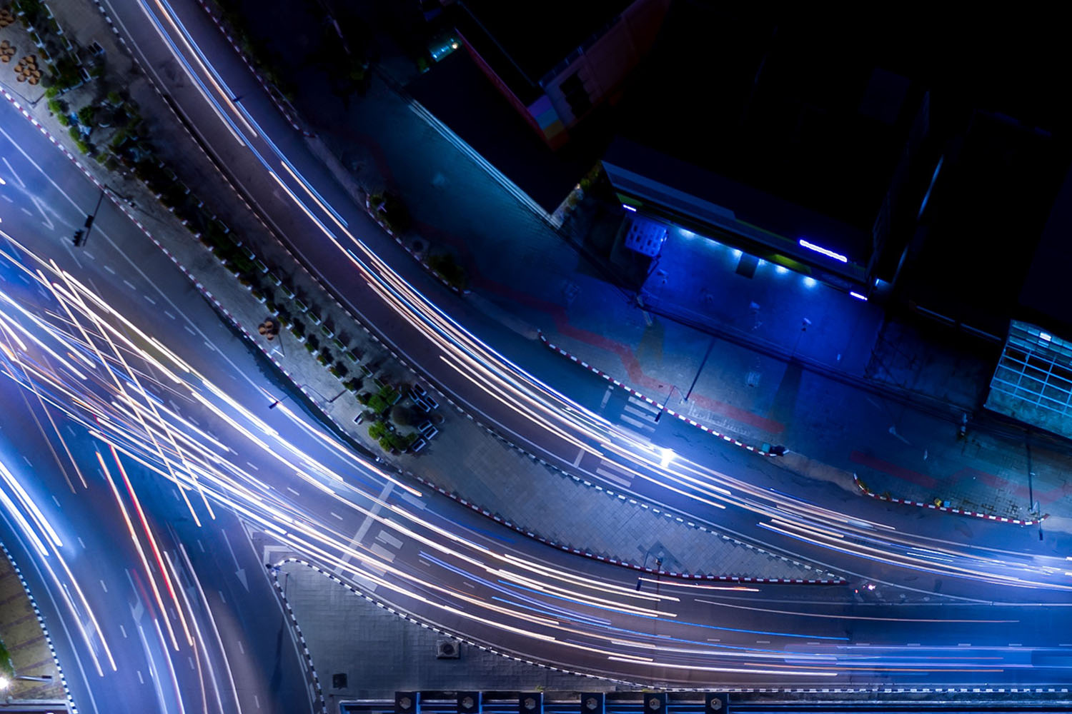 aerial view of streets at night with blurry head and tail lights.