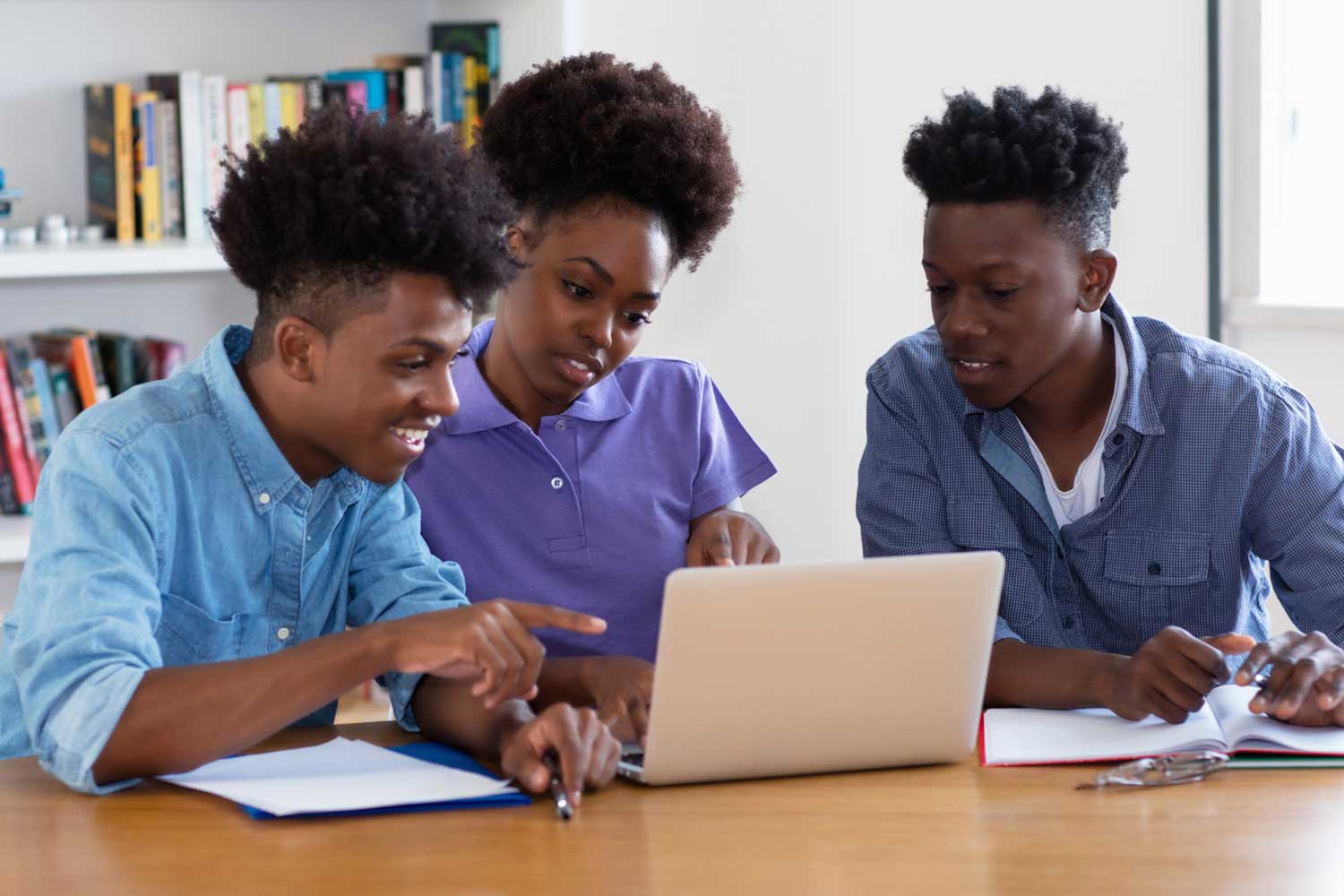 Three young people looking at a computer