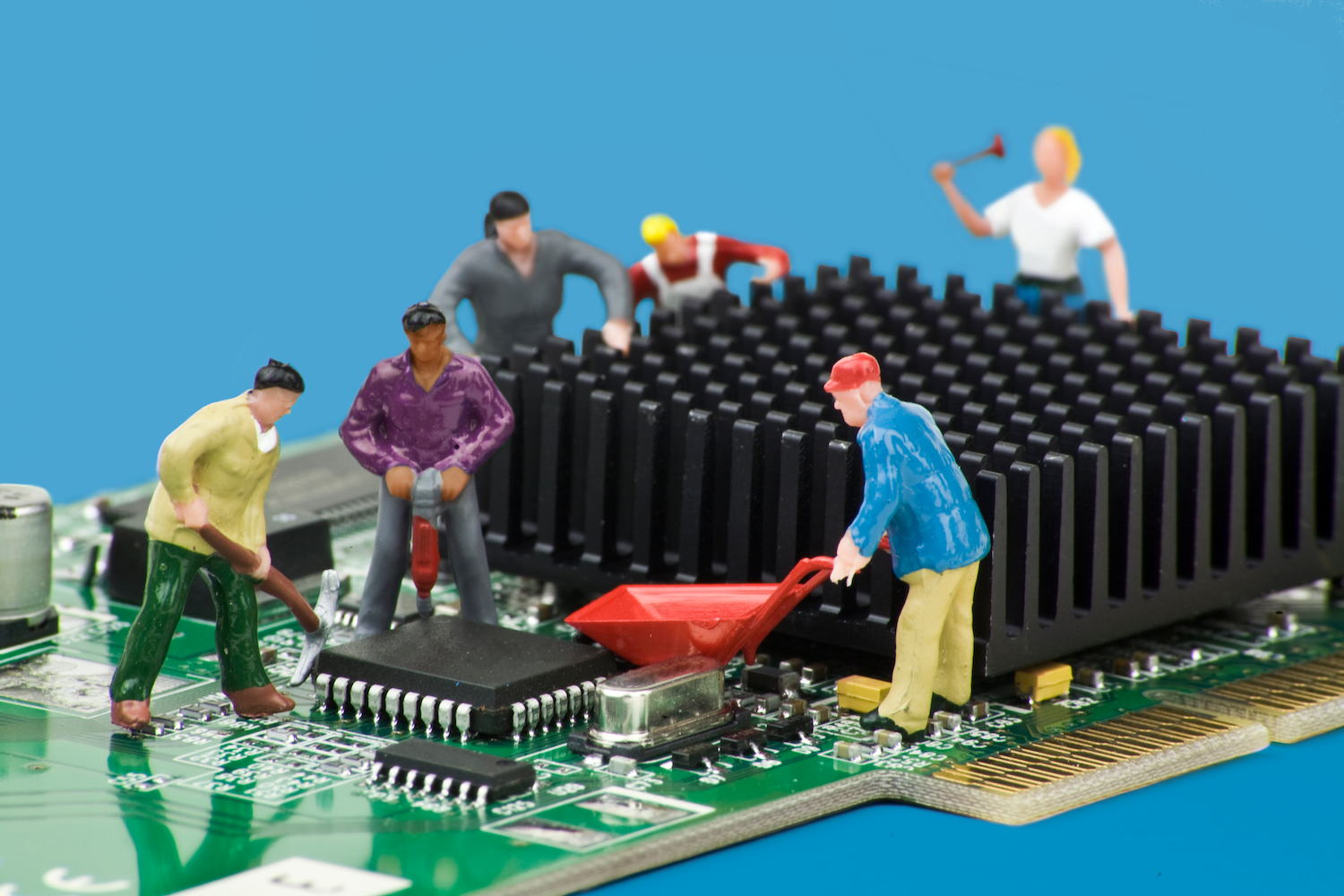 Miniature diorama of construction workers at work on a computer board (PCB)