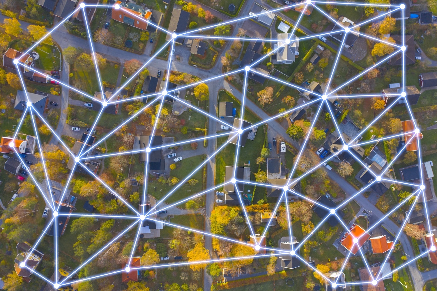 aerial view of suburban neighborhood overlayed with glowing lines of a network diagram