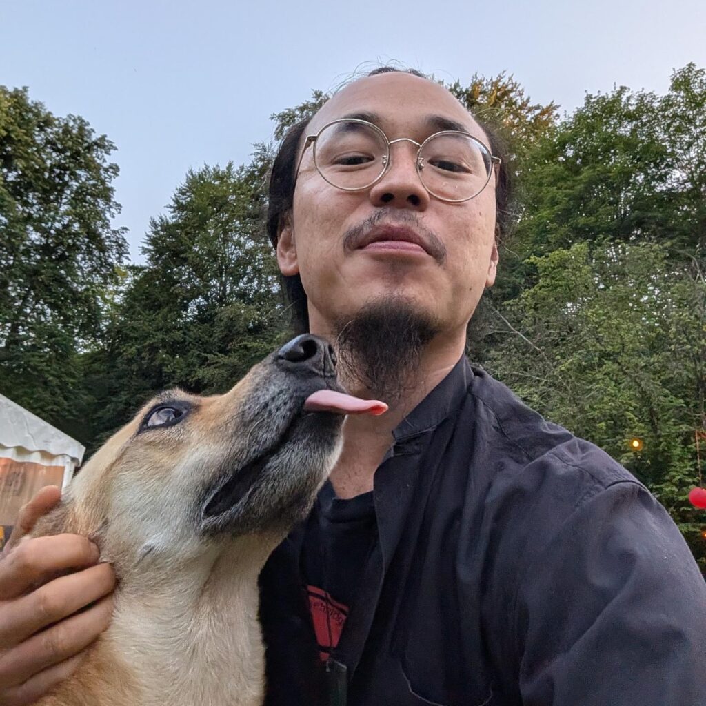 Tony Lai with a dog licking face